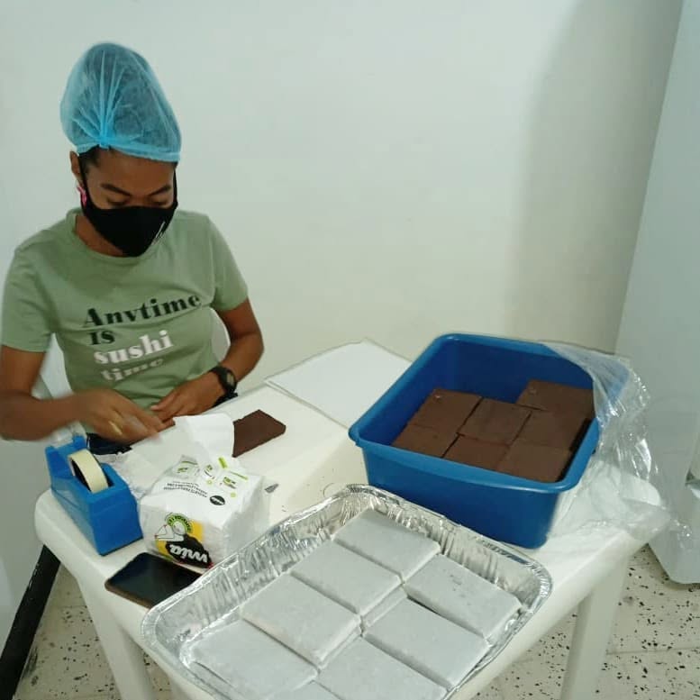 Equipo de mujeres de Chocomueic empacando chocolate en la planta