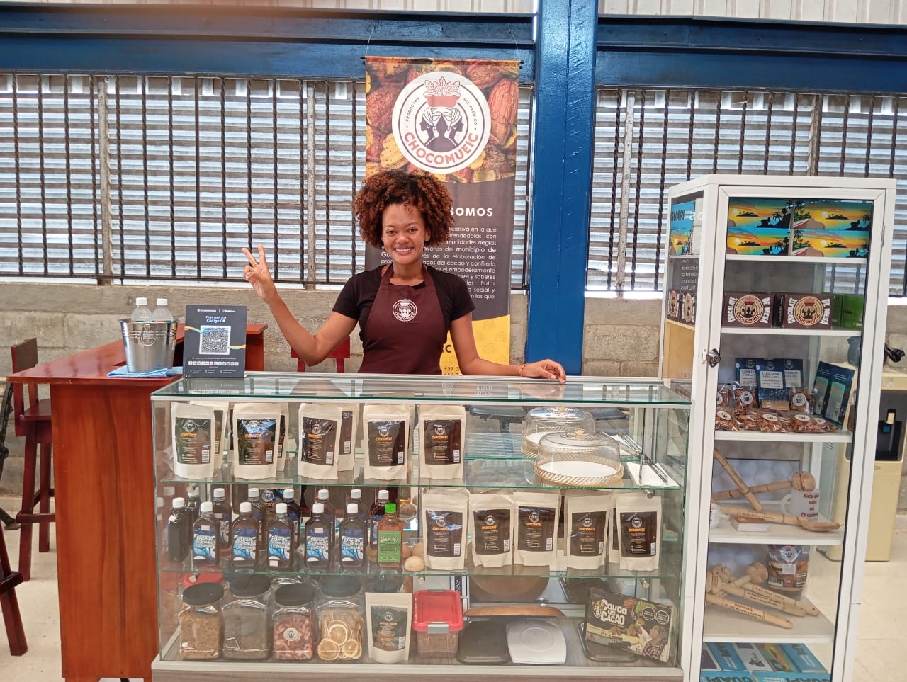 Emprendedora de Chocomueic en el punto de venta con la línea de productos de cacao